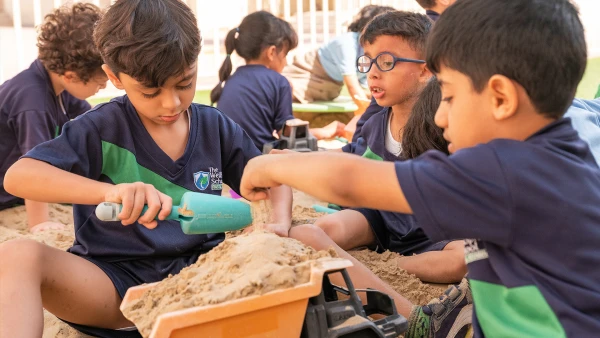 wellspring private school early childhood students playing in sand with dump trucks and shovels
