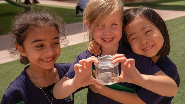 wellspring private school elementary students holding insect in clear jar