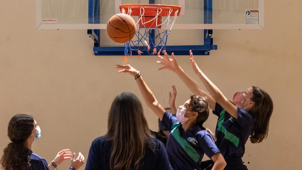 Secondary girls playing basketball learning about WellSpring Private School teamwork