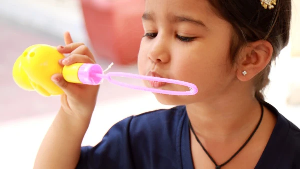wellspring private school early childhood student blowing bubbles