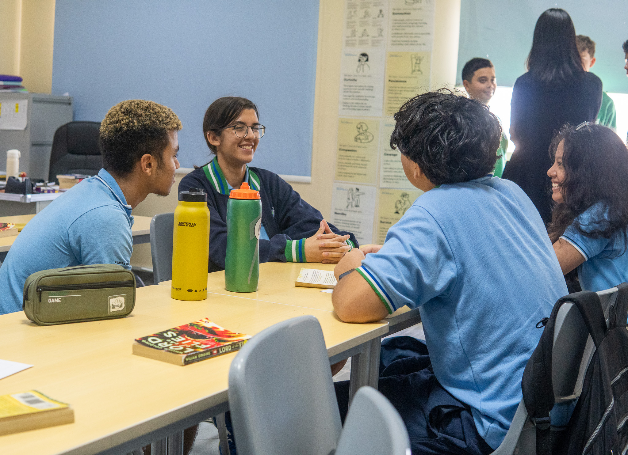 WellSpring students sitting at a table, smiling in class.