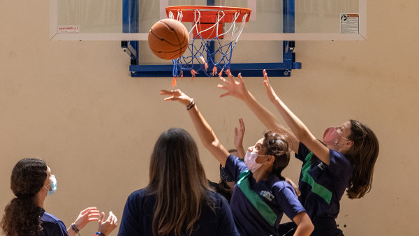 Secondary girls playing basketball learning about WellSpring Private School teamwork