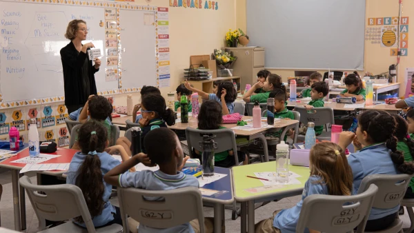 female teacher at WellSpring Private School learning how to communicate with her young class of students